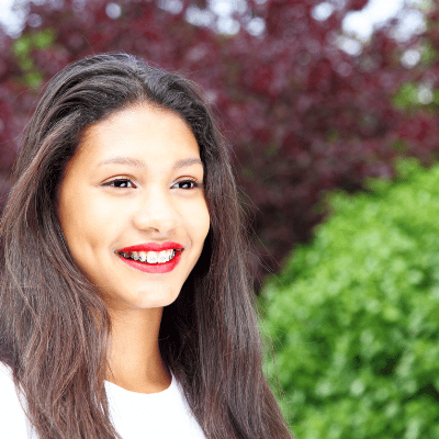 young girl smiling wearing red lipstick and braces