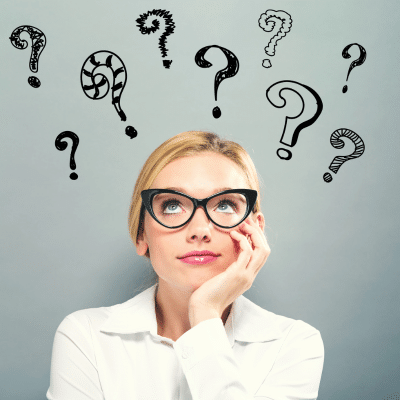 Teenage girl wearing glasses, looking up at a number of question marks, representing braces and aligners